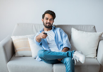 Smiling Young Middle Eastern Guy Watching TV At Home.