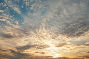 Morning blue orange sky, sun shining through clouds