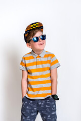 Funny little boy in sunglasses express surprised face, isolated on white background. Kid in cap. Cool boy kidding. School boy on summer vacation