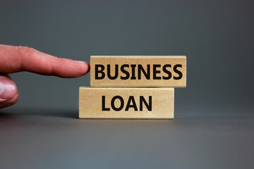 Time to business loan. Concept words 'business loan' on wooden blocks on a beautiful grey backgrounds. Businessman hand. Business loan concept.