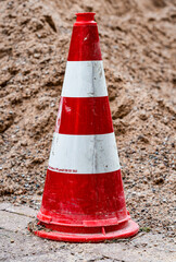 Leitkegel vor einem Sandhaufen