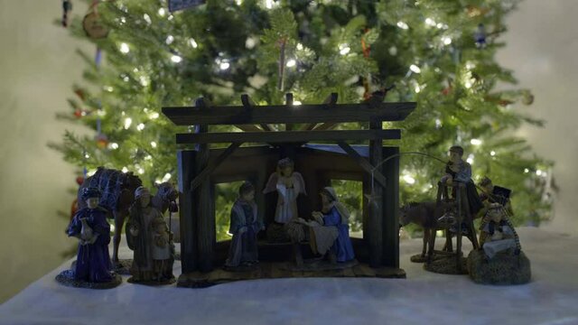 Close up, nativity set in front of Christmas tree