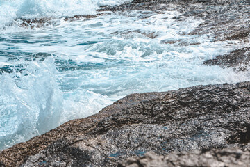 view of rocky seaside waves with white foam