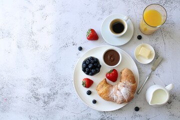 Breakfast in Italian style with pastries, hot coffee, nutella, butter, berries and juice on a light background, top view. Traditional italian breakfast with coffee, nutella and berries, copy space