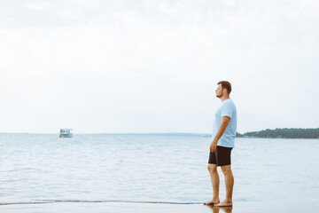 man walking barefoot by sea beach summer time