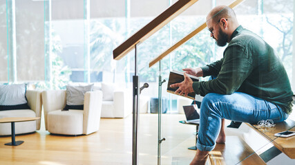 Fototapeta premium Thoughtful man flipping through pages of book at home
