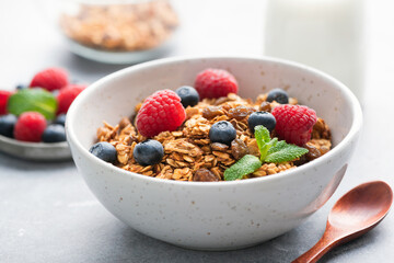 Bowl of homemade granola with berries. Healthy breakfast food, cereals bowl with raspberry blueberry