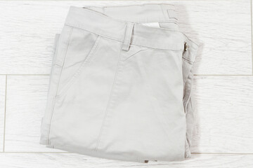 closeup folded pants on white wooden background - top view