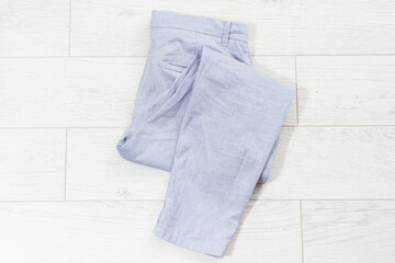 closeup folded pants on white wooden background - top view