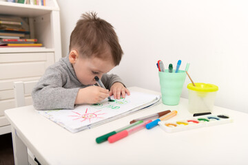 Small boy drawing in his room. Happy childhood concept