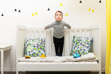 Young caucasian boy plays with colorful toys in his room. Happy childhood concept