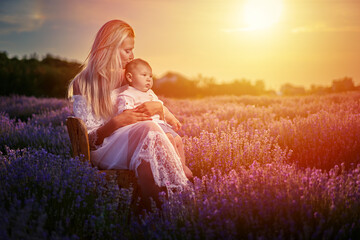 Fototapeta na wymiar Mother and little boy in a lavender field at sunset