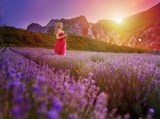 Woman running through a lavender field with mountains behind