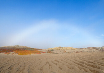Fototapeta na wymiar soft rainbow over beach dunes