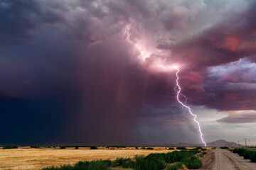 Desert thunderstorm with lightning bolt at sunset
