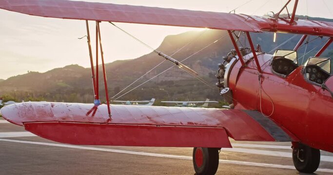 Medium shot, vintage red plane at sunset