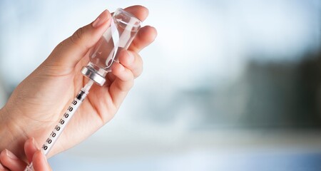 Human hand with injection syringe and vaccine - obrazy, fototapety, plakaty