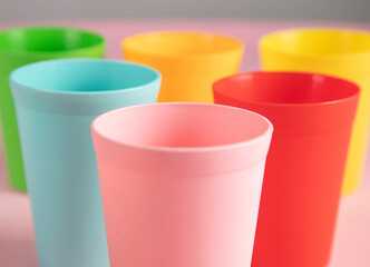 color plastic cups on pink background