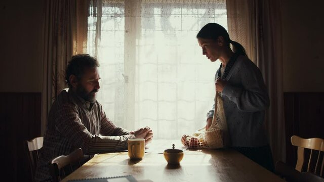 Side view of poor mature couple indoors at home, poverty concept.