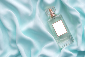 Bottle of perfume on a blue silk cloth