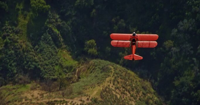 Aerial, vintage plane with stuntman on top