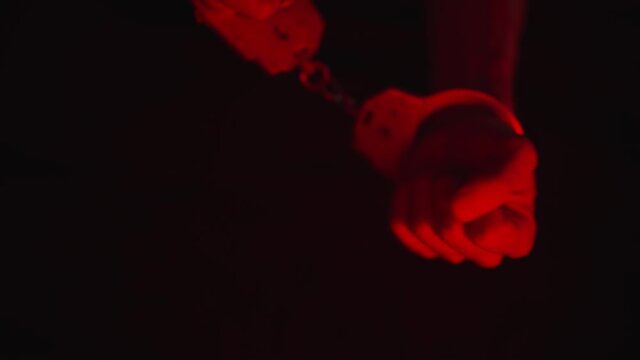 The police take the handcuffed prisoner to the prison. Detention of a suspect. Red and blue light from a police flashers.