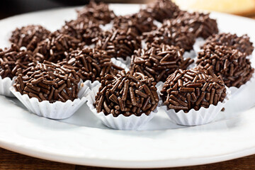 Tradicional Brazilian Snack Brigadeiro on a plate on a wooden background