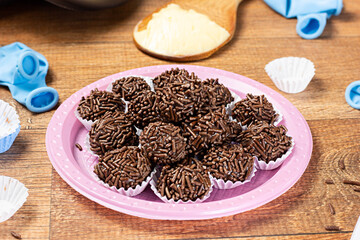 Tradicional Brazilian Snack Brigadeiro on a plate on a wooden background