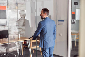 Fototapeta premium Happy adult caucasian man is working in a modern office