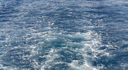 Turbulent flow of a boat wake. Sea wave. The yacht sails, leaving behind a trail and waves.