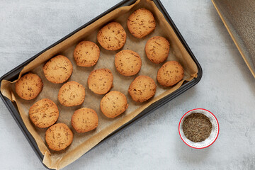 Freshly baked cookie biscuits with cumin spice in baking tin. Flat lay view of jeera biscuits snacks.