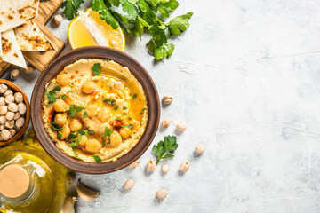 Hummus with olive oil and paprika at light kitchen table.