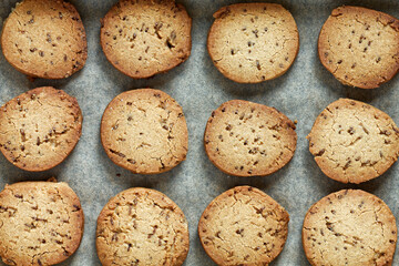 Freshly baked cookie biscuits with cumin spice in baking tin. Flat lay view of jeera biscuits snacks.