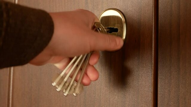 Close-up, a man's hand closes the door with a key