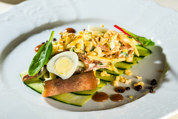 beautiful cucumber salad with meat, egg and basil on a platter in a restaurant