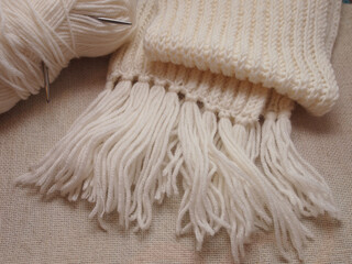 Fototapeta na wymiar white hand-knitted scarf on canvas