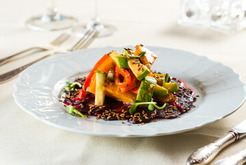 fresh vegetarian salad on a platter of pumpkin, zucchini, beetroot, flax seeds, raw wheat, peach, pepper with dressing.