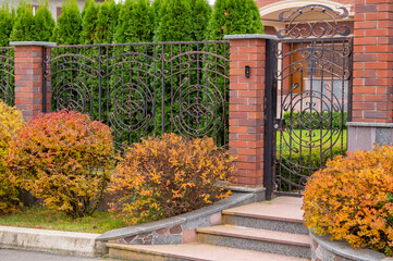 forged metal wicket with a fence and pillars on the street