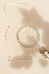 Glass petri dish with transparent pure serum for skin care
