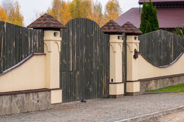 wooden gate with stone pillars and a fence using natural materials