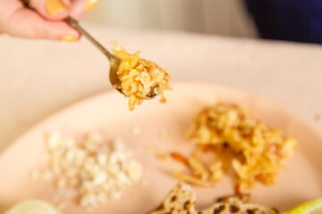 Haroset of apples and nuts for seder pesach in a spoon in a woman's hand.