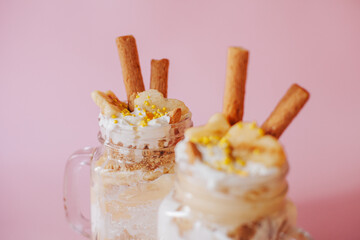Delicate creamy banana dessert in a glass on a green background.