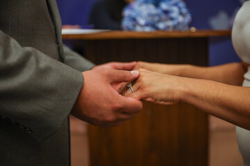 close up of a bride and groom holding hands