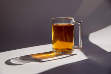 black tea in a clear glass on a white background with shadows