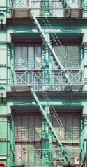 Fototapeta na wymiar Old green building with iron fire escape, New York City, USA.