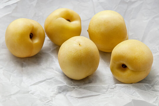still life of yellow nectarines on parchment close up