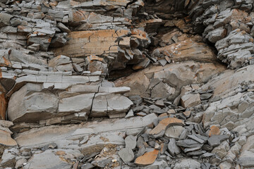 Gray striped rock. Texture natural minimalistic stone background. Unusual rock orange light gray close up.