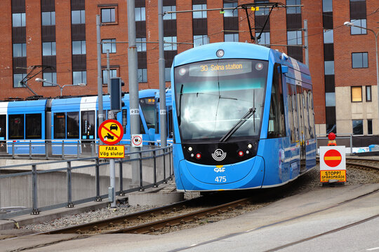 Solna, Sweden - March 30, 2021: A pair of articulated trams of class A35 operates the Tvarbanan line number 30 at Solna Business park heading for Solna station in the greater Stockholm area.