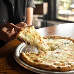 Piece of Melted Cheese Pizza. Female Person takes slice of hot Delicious pizza. Close up shot....