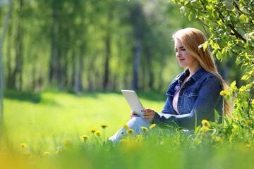 Young woman using tablet in park